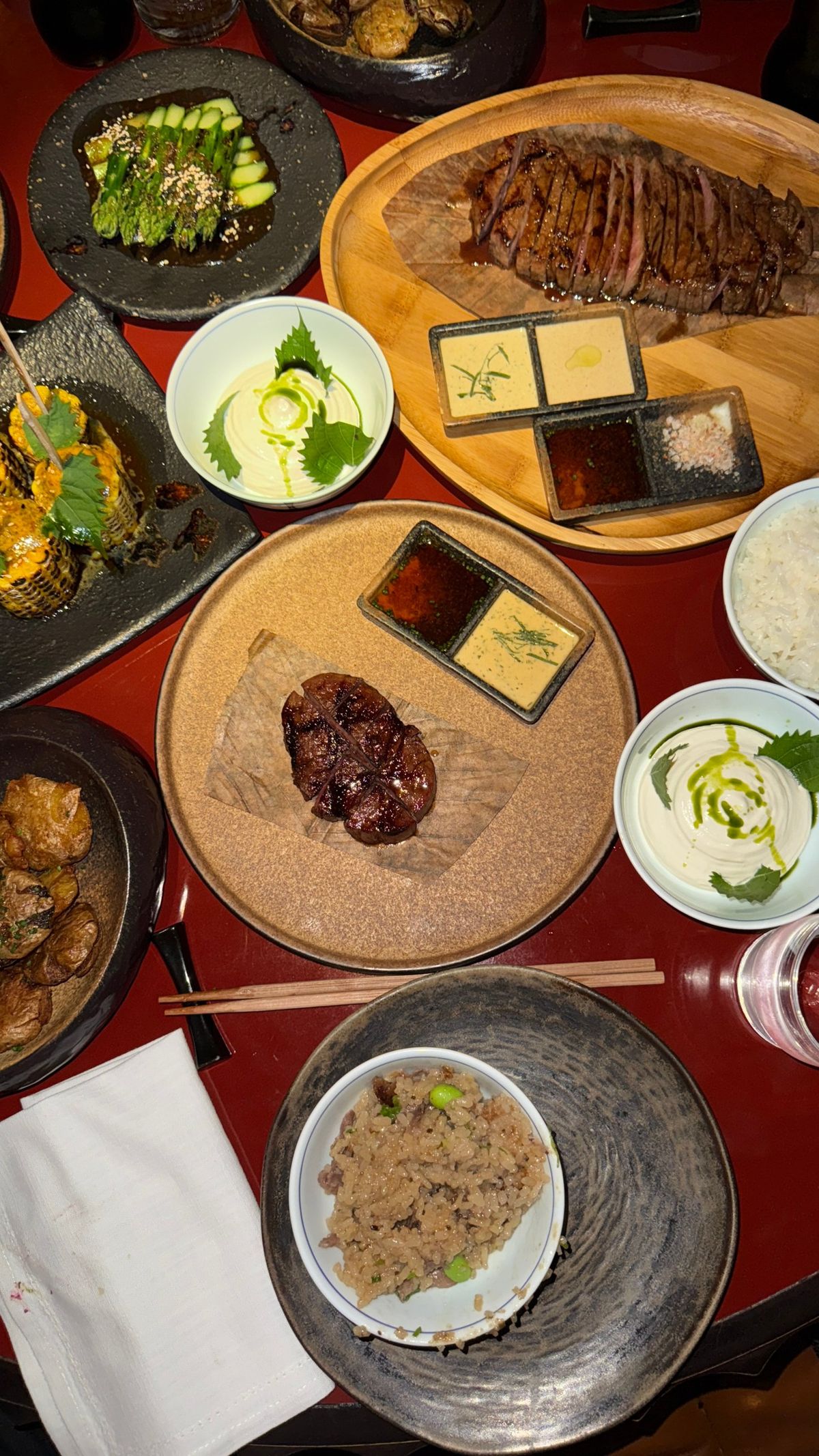 A table of Japanese grilled wagyu, corn and asparagus dishes