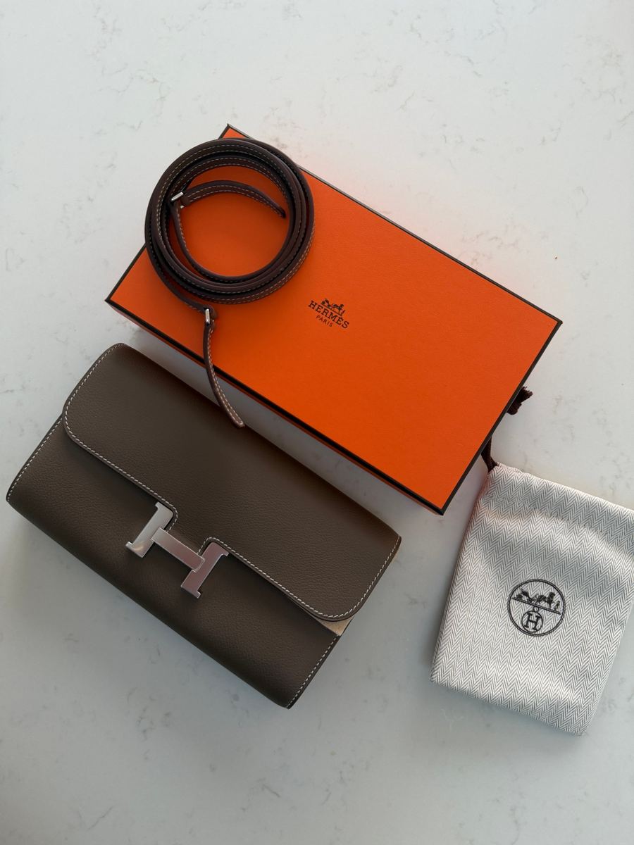 A taupe Hermès Constance with its orange box and dust bag