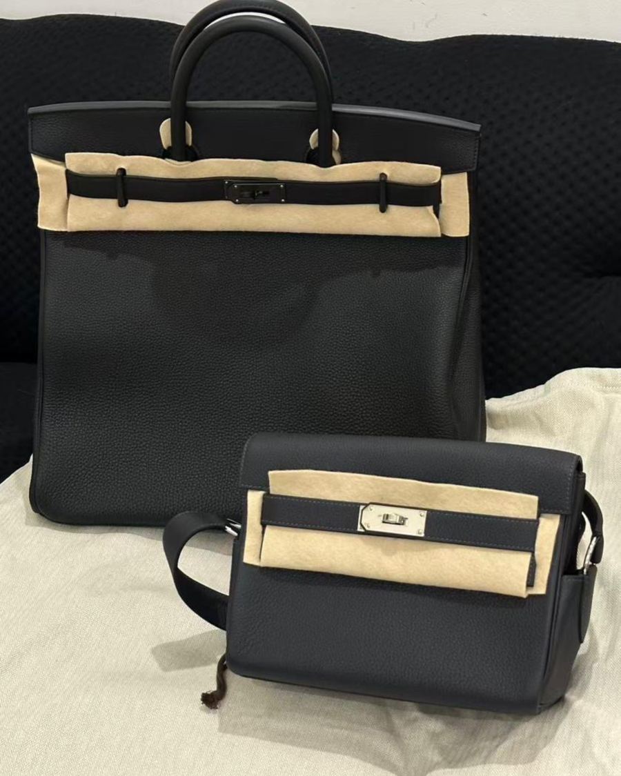 Two black Hermès bags in their protective felt